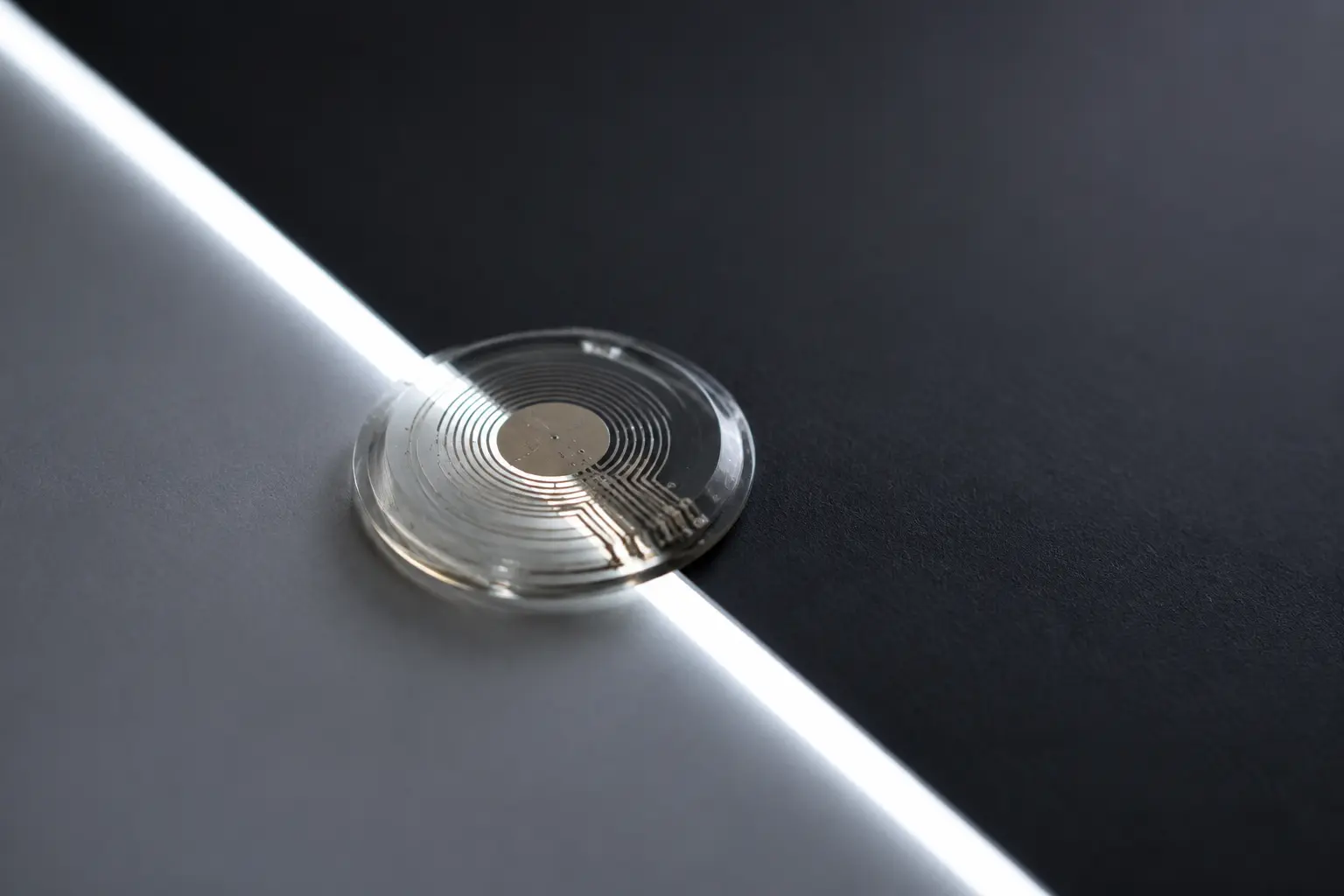 A translucent circular interface resting across a line of light